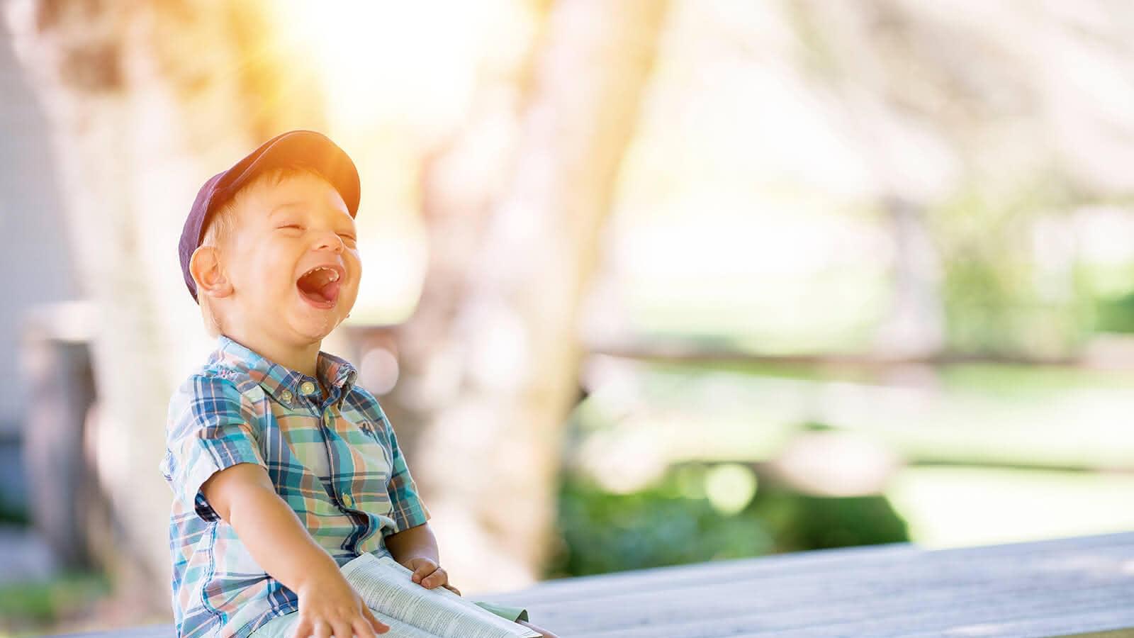 Lachendes Kind auf einer Bank